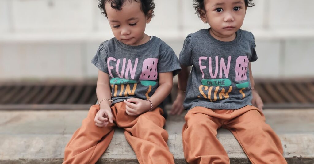 3歳と4歳の双子がそれぞれ異なる遊びを楽しんでいる場面