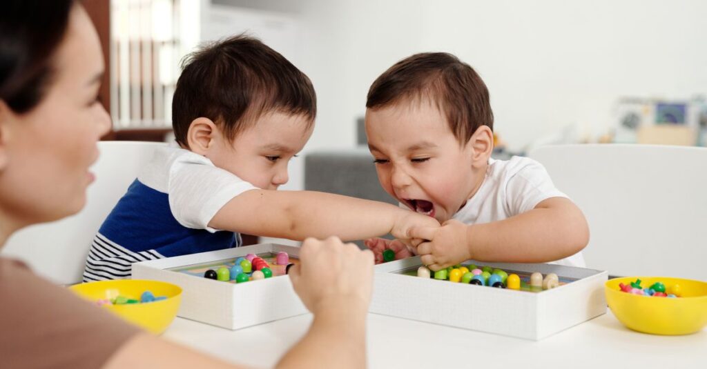遊び中にトラブルが起きた2歳の双子を優しく見守りながら解決する母親の姿